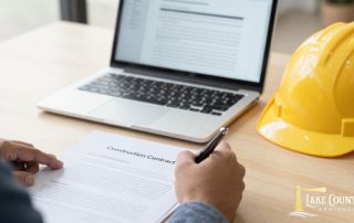 Construction contract being reviewed and signed in an office.